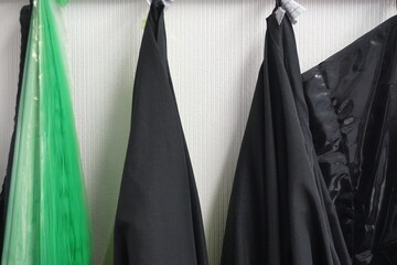 Schwarze Frisierumhänge an Garderobe im Friseursalon