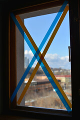 Kyiv/Ukraine - 26 February 2022: War Ukraine Russia. This is a window that is covered with ribbons in the colors of the Ukrainian flag to prevent the formation of broken glass.