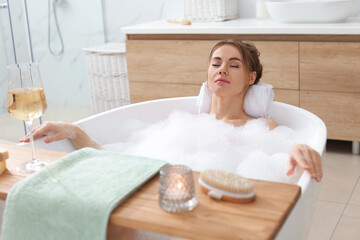 Naklejka premium Beautiful woman enjoying bubble bath at home