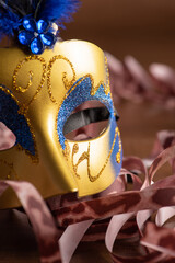 Carnival masks, beautiful venetian masks in detail with serpentine on a table, selective focus.