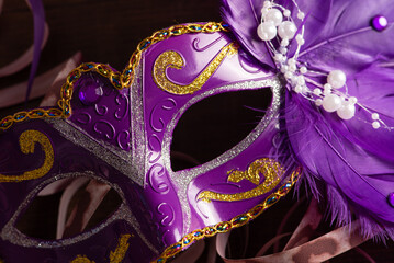 Carnival masks, beautiful venetian masks in detail with serpentine on a table, selective focus.