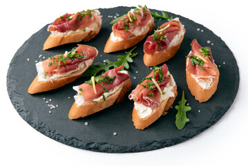 Vassoio di crostini farciti con formaggio, rucola e prosciutto crudo, antipasto italiano 