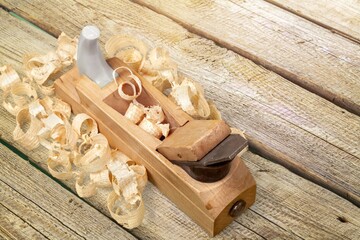 Plane jointer carpenter or joiner tool and wood shavings. Wood working tools on wooden table. Carpentry workshop