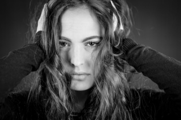 Portrait of a beautiful young woman with long hair with her hands in her hair with intense and...