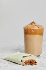 Coffee frappé, cold caramel coffee with white alfajores with dulce de leche on a marble table