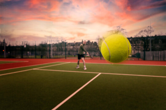 Selective focus of a yellow tennis ball in the air during a match