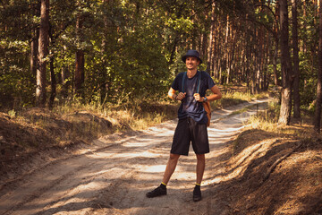 Young handsome man  with joyful smile walking outdoors in the national park