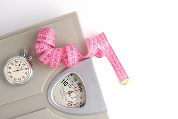 Floor scales, stopwatch and measuring tape on a white background.Weight loss and sports.