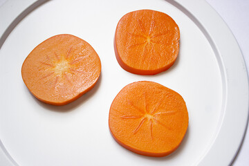 Cut Japanese persimmons on a plate. Japanese style image.