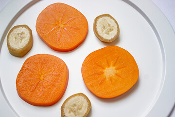 Cut Japanese persimmons on a plate. Japanese style image.