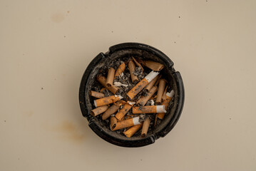 Top view of a black ashtray with cigarettes