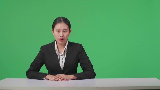 Live News Studio With Professional Asian Female Anchor Reporting On The Events Of The Day On The Green Screen
