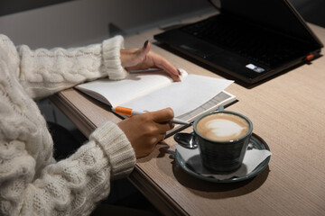 Fototapeta na wymiar workplace - human hands with notepad and pen and coffee