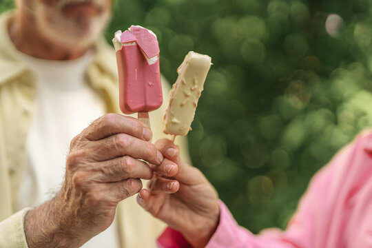 View Of An Old Couple Eating Ice Cream In A Garden