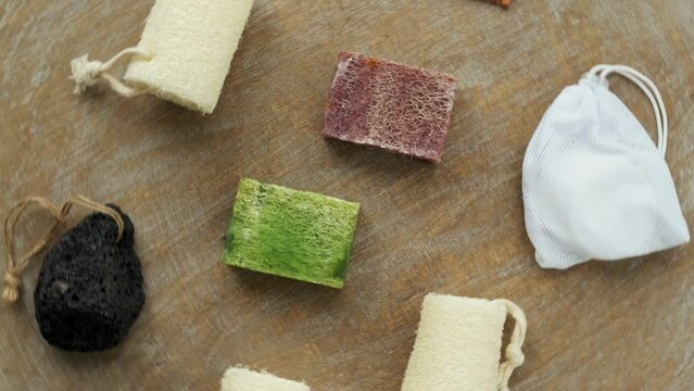 Soap with loofah sponge and other hygiene accessories. Top view, table spin.