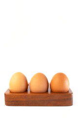 Chicken eggs in a wooden tray, isolated on a white background. Concept ready-to-cook eggs, fresh from the farm