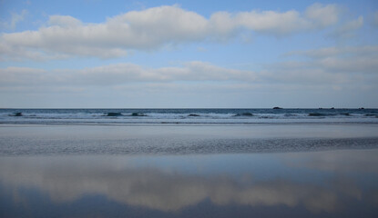 Reflections of the sky on the sea shore at low tide, Famara beach, Lanzarote, Canary Islands