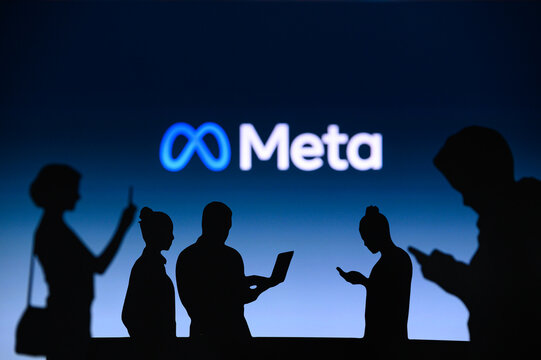 NEW YORK, USA, 1. MARCH 2022: Meta or Metaverse logo on big screen, Facebook company, Meta Platforms. business and employment-oriented online service Group of business people chat on phone and laptop