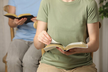 Women reading Bibles at home together, closeup