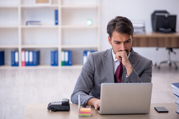Fototapeta premium Young male employee working in the office