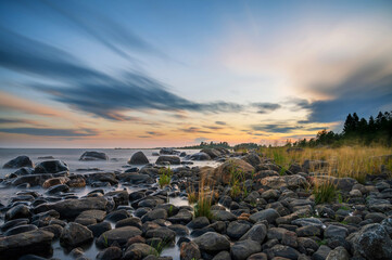 Long Exposure of Magnificent Soft and colorful sunset by the seaside stone. Beautiful cloud movement