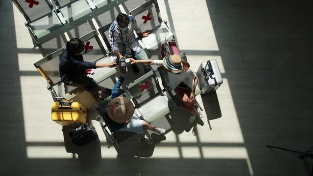 Top view traveler group wearing face mask new normal greeting together and make social distancing at public terminal station.