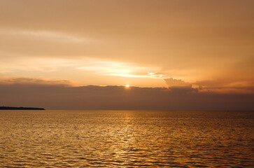 Obraz premium Picturesque seaside resort town in Slovenian coast against orange sunset sky in summer. Scenic view of Adriatic sea in the evening. Travel concept