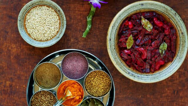 Grated beetroot curry with coconut and cashews with spices in Masala Dabba spice box. Indian cuisine, table spin.