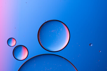 Composition of big and small colored circles oil drops on water.