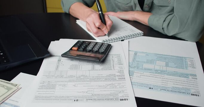 Woman calculate and filling US tax form 1040 in tax time. Individual Income Tax Return Form 1040