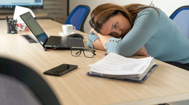 A tired employee experiences a period of burnout at work.Physical and emotional exhaustion of an employee.Burnout concept.