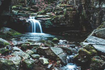 Low angle shot of a waterfall flowing on a sunny day © Jakub Kramný/Wirestock