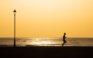 Fototapeta premium silhouette of a person running on the beach path