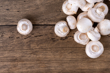 Fresh raw organic champignons heap on a wooden table.