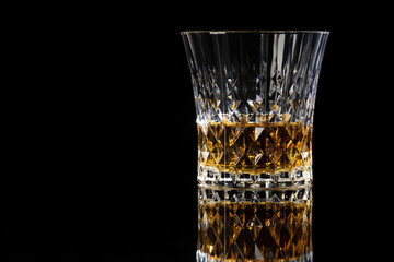 Isolated shot of whiskey with reflection on black background
