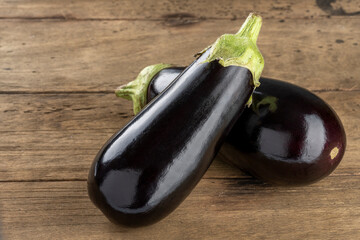 two fresh eggplants on a wooden table