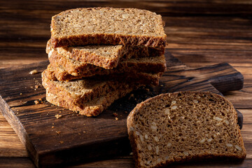 Bread, traditional homemade bread cut into slices on a rustic wooden background, close-up.
