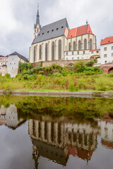 Fototapeta na wymiar St. Vitus church reflected in Vltava river, Cesky Krumlov, Czech Republic