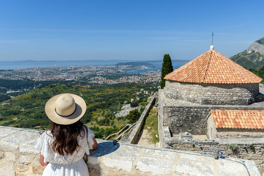 Female with a hat standing at Klis fortress above city of Split, Croatia