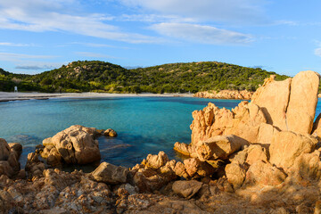 Fototapeta na wymiar Les plages paradisiaques de la Costa Smeralda du nord de la Sardaigne avec l'eau turquoise et les roches de granit sous le soleil et le ciel bleu