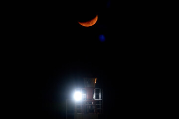 Sunset with moon over Lighthouse. Super blood moon. The moon in the night sky.