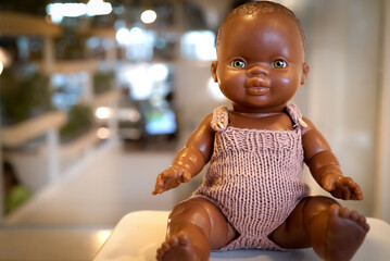 Black baby doll on a blurred background