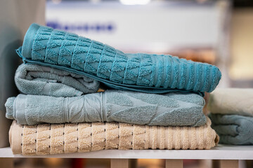 Several fresh folded bath towels on shelf