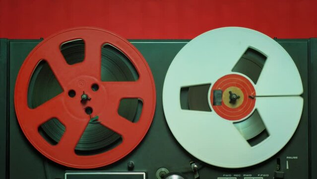 Vintage recording music concept b-roll footage. Close up shot of a reel to reel tape, rolling