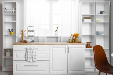Interior of light kitchen with white shelving units