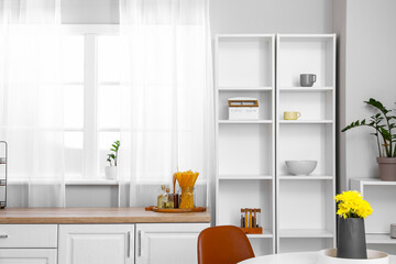 Interior of light kitchen with white shelving unit