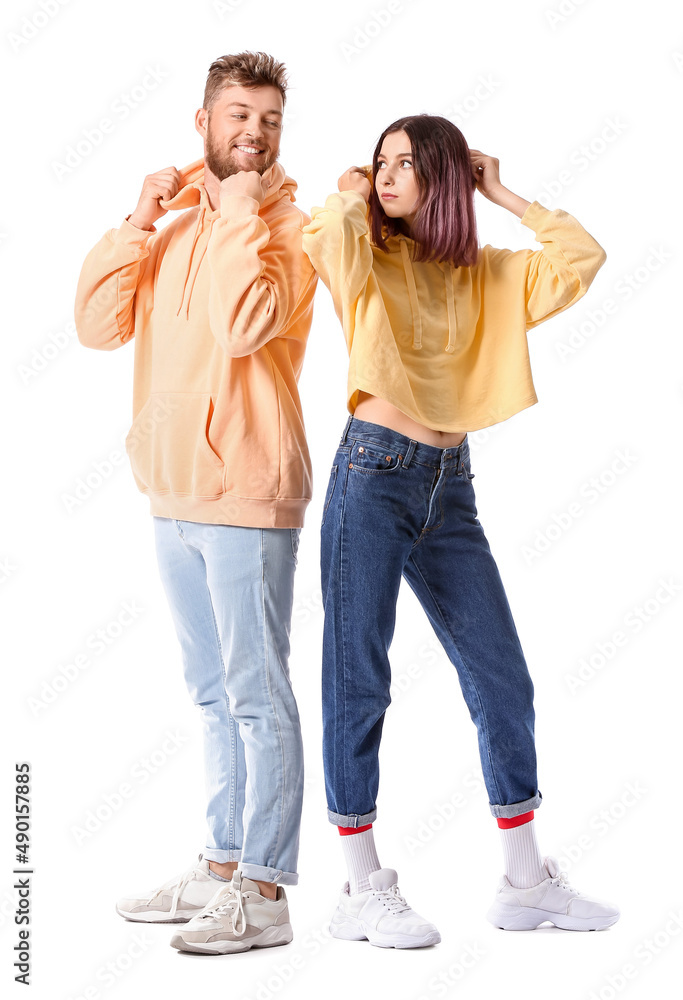 Wall mural Cool young couple in hoodies on white background