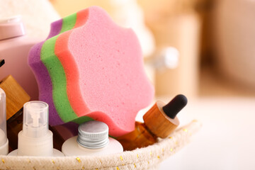 Basket with cosmetic products and bath sponge, closeup
