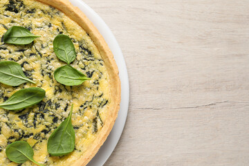 Delicious homemade spinach pie on white wooden table, top view. Space for text