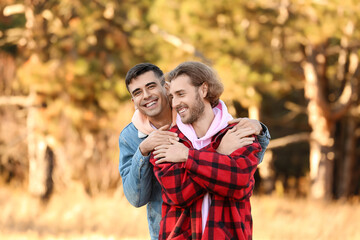 Happy gay couple outdoors on autumn day